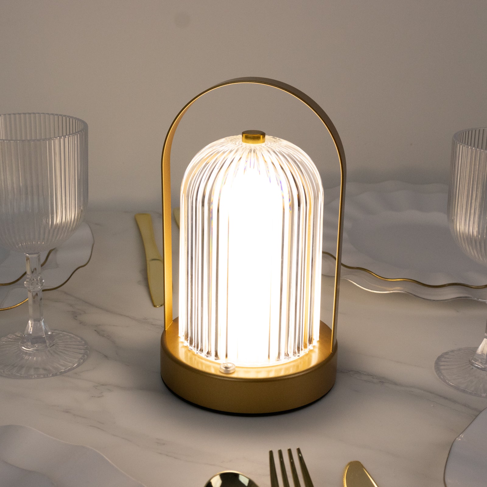 Gold metal LED table lamp with ribbed acrylic shade, cordless and touch control.