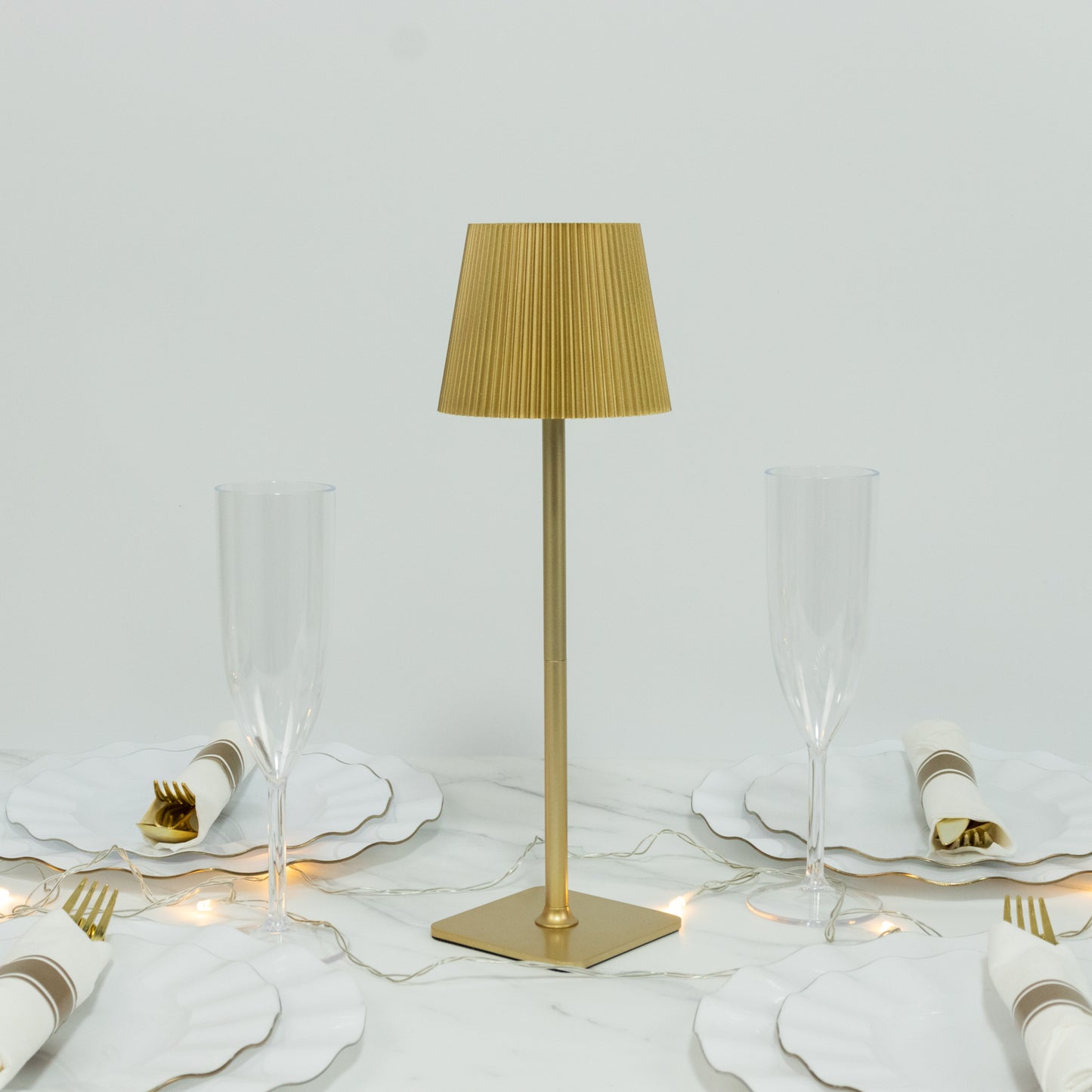 Gold cordless LED table lamp with adjustable height and ribbed shade.