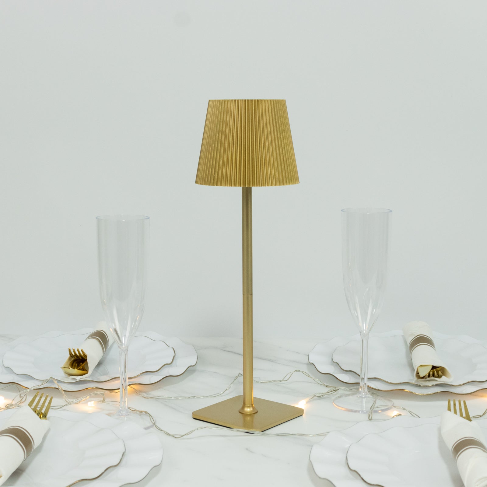 Gold cordless LED table lamp with adjustable height and ribbed shade.
