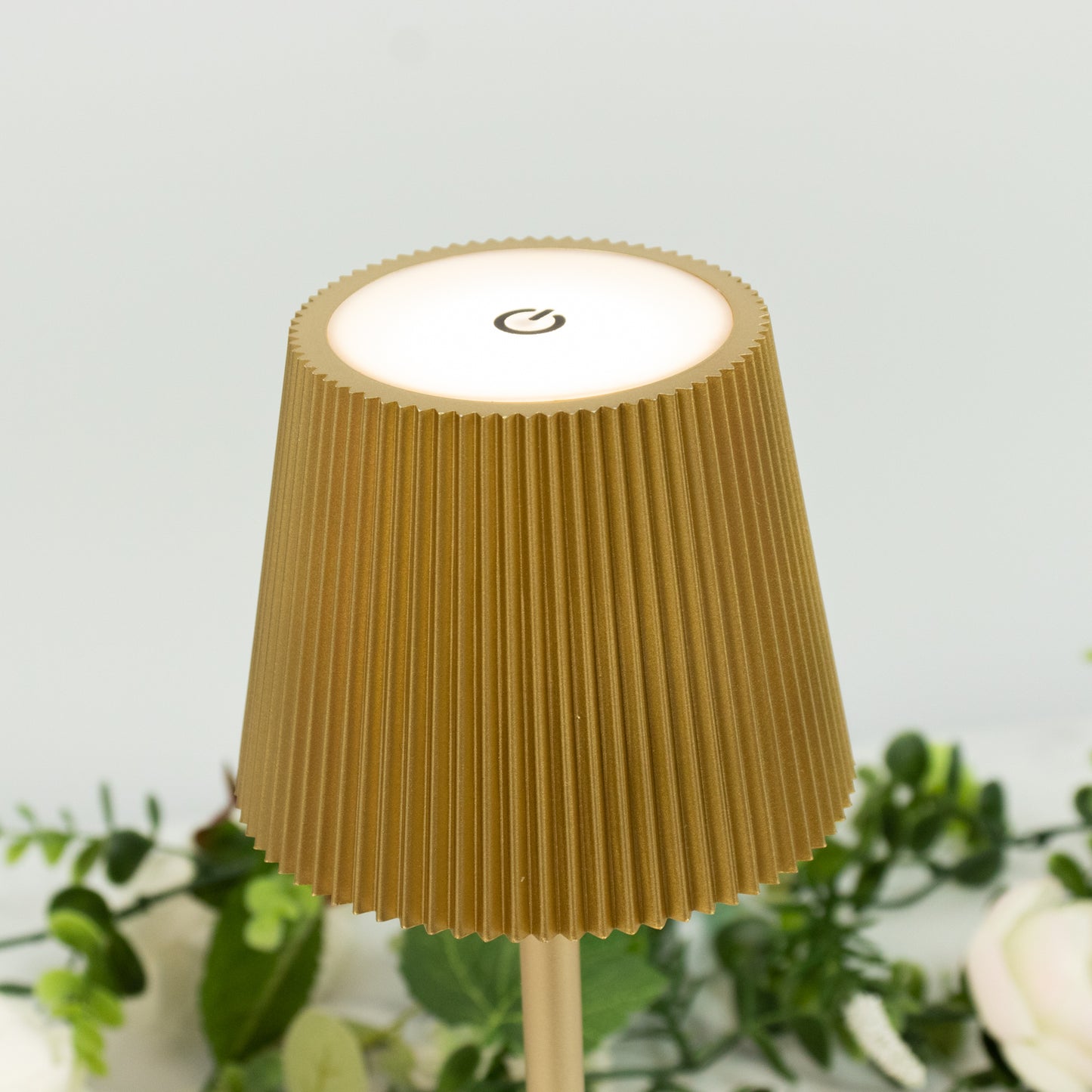 Gold cordless LED table lamp with ribbed shade and touch control.