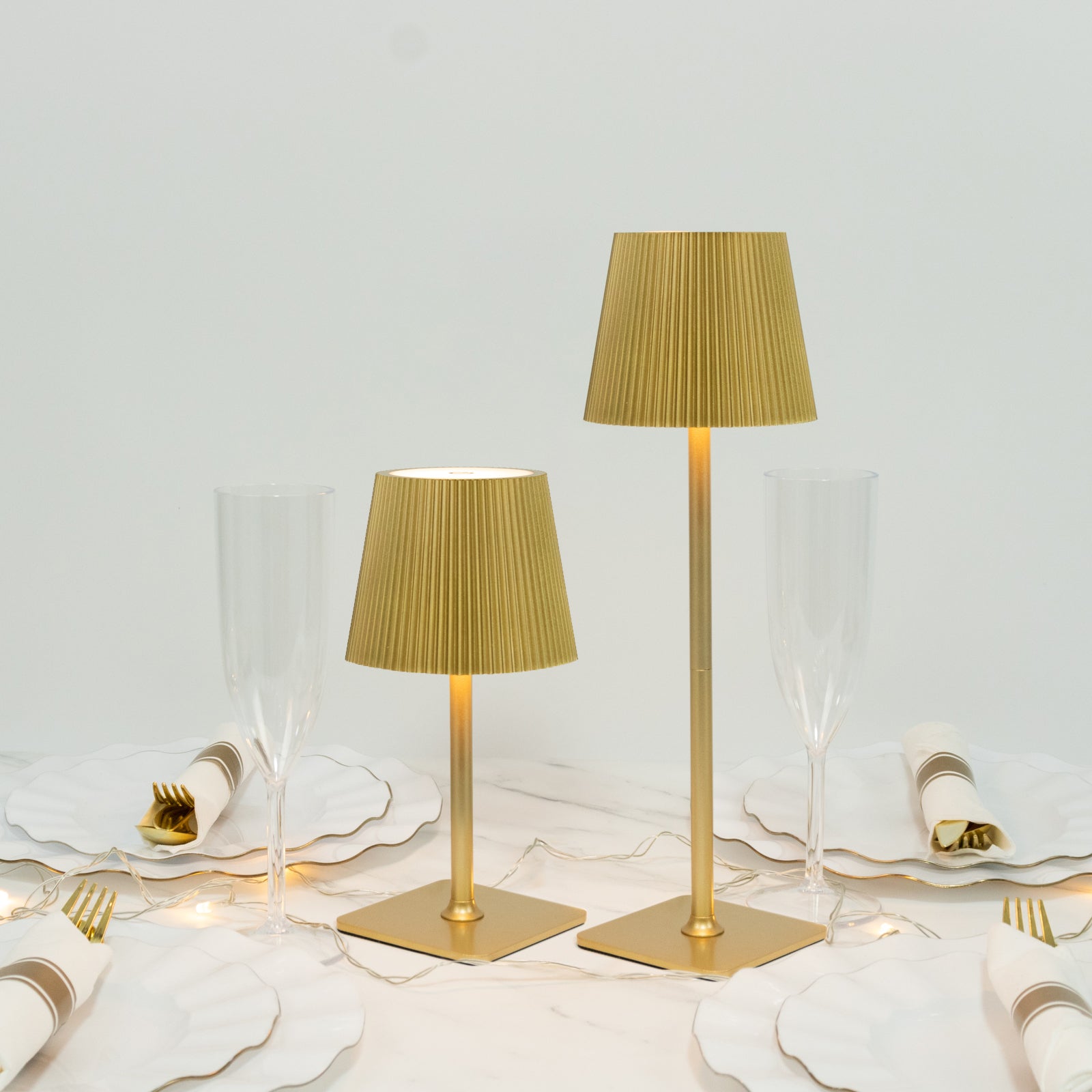 Gold cordless LED table lamp with ribbed shade and adjustable height.