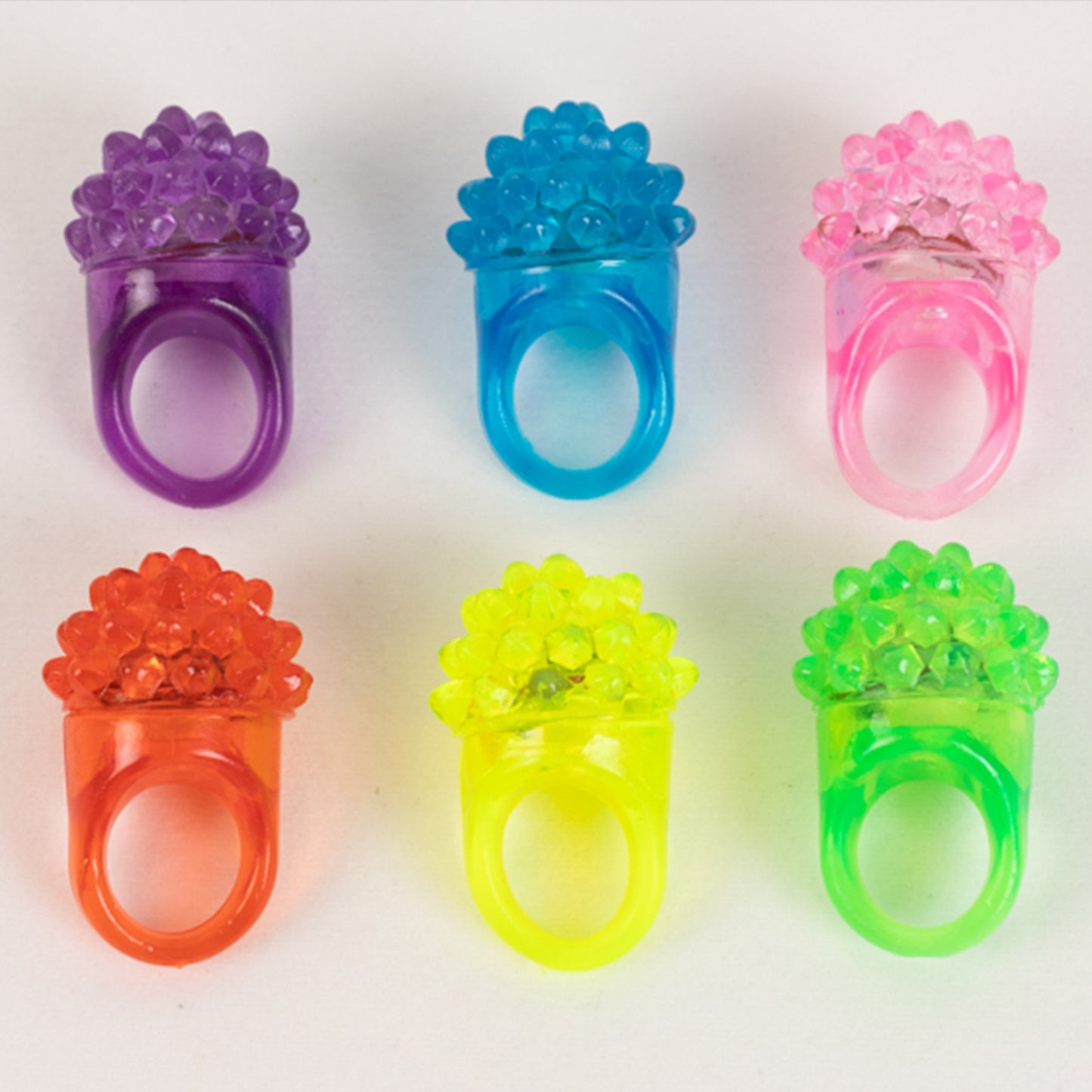 Colorful LED light-up rings in purple, pink, blue, orange, and yellow.