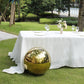 Gold reflective garden gazing ball on a green lawn.