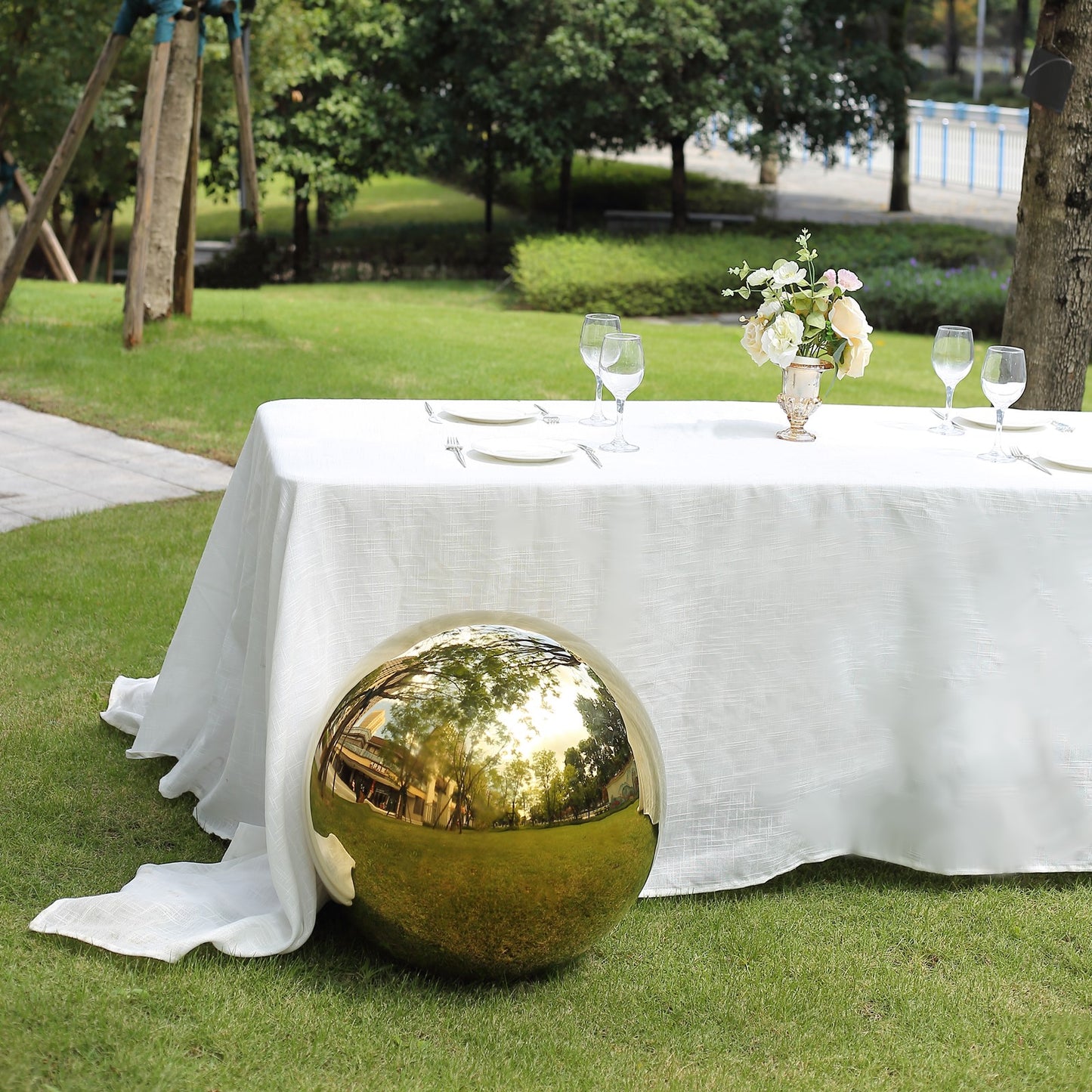Gold reflective garden gazing ball on a green lawn.