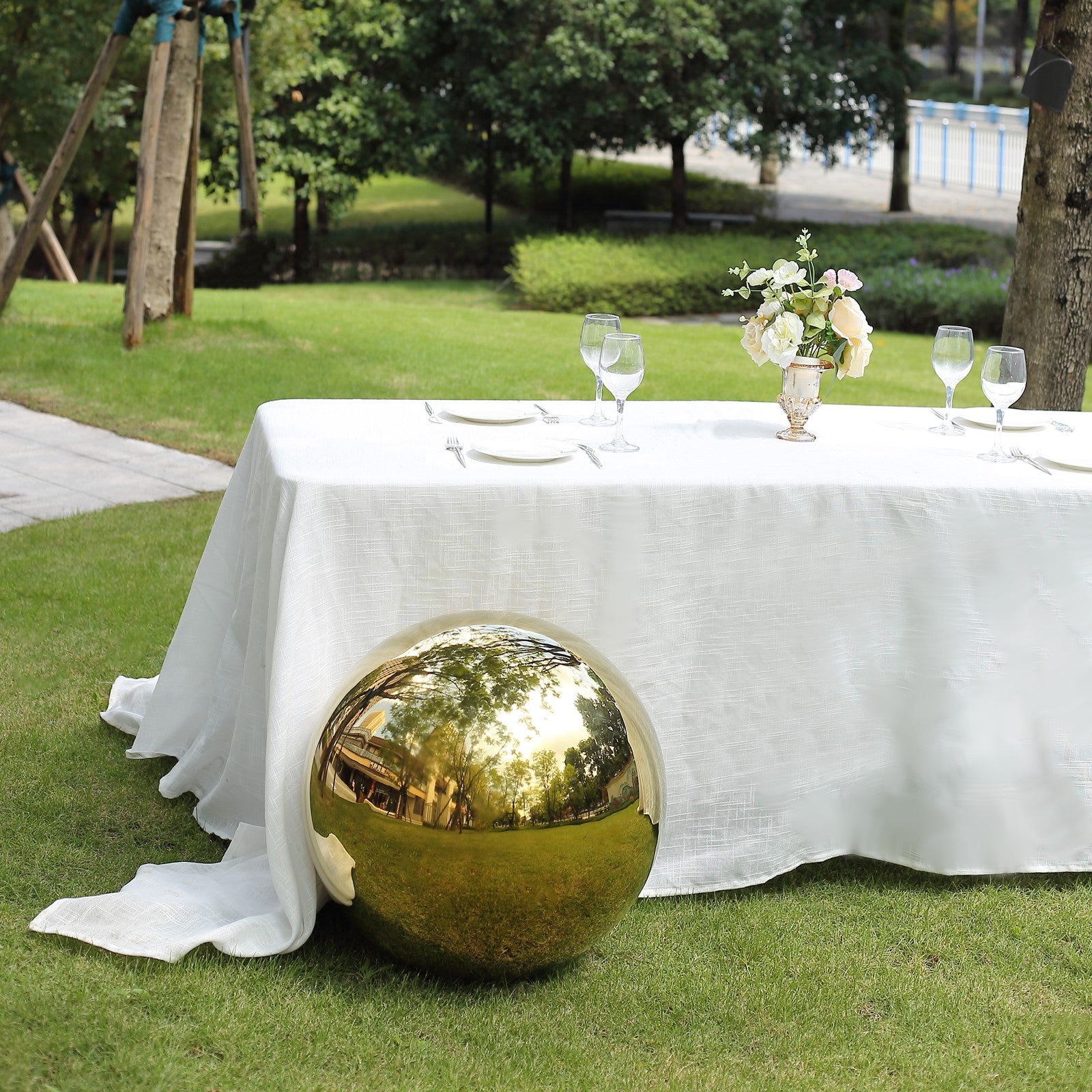 Gold reflective garden gazing ball on a green lawn.