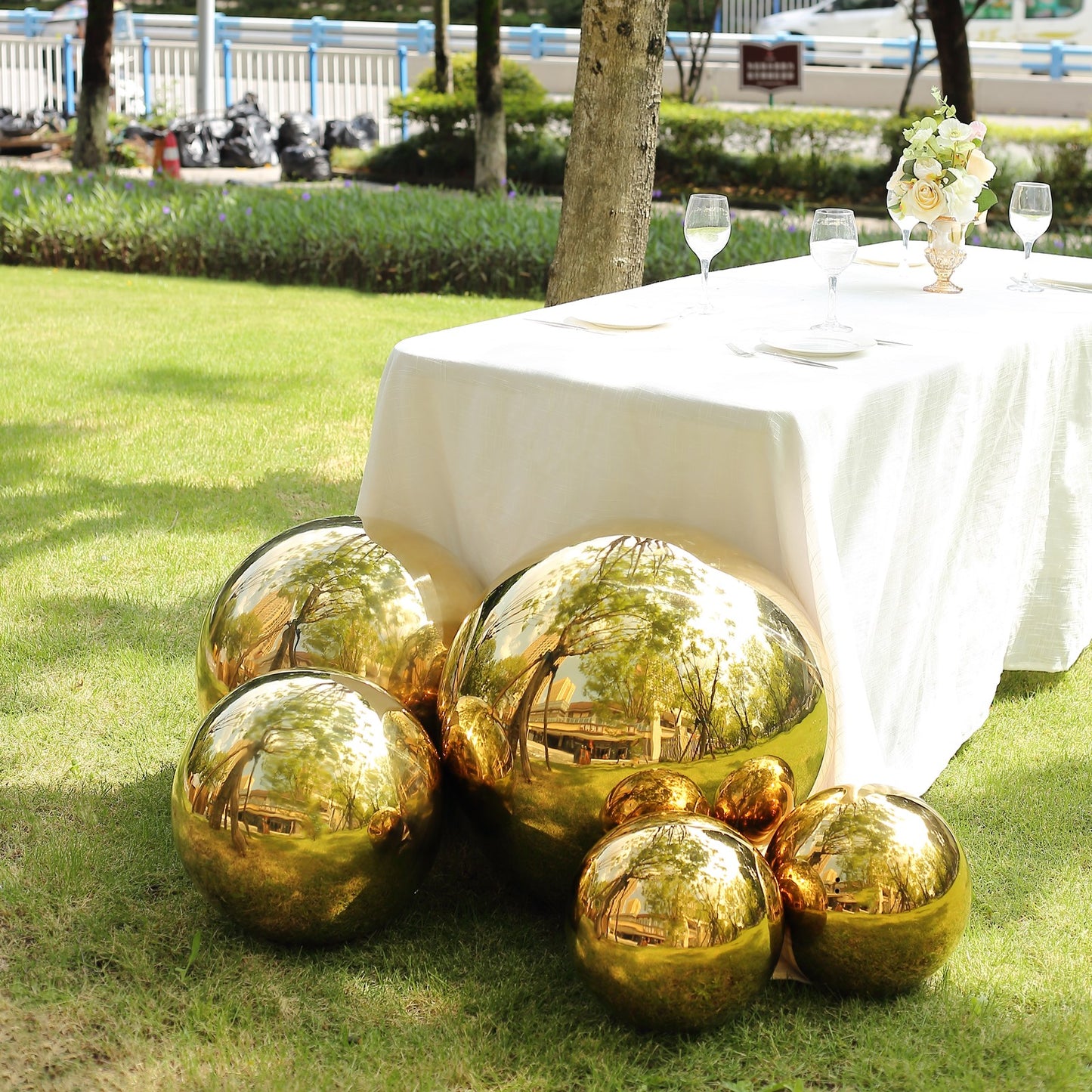 20" Gold Stainless Steel Shiny Mirror Gazing Ball in garden setting.