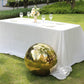 Gold reflective garden globe sphere on a table in a green garden.