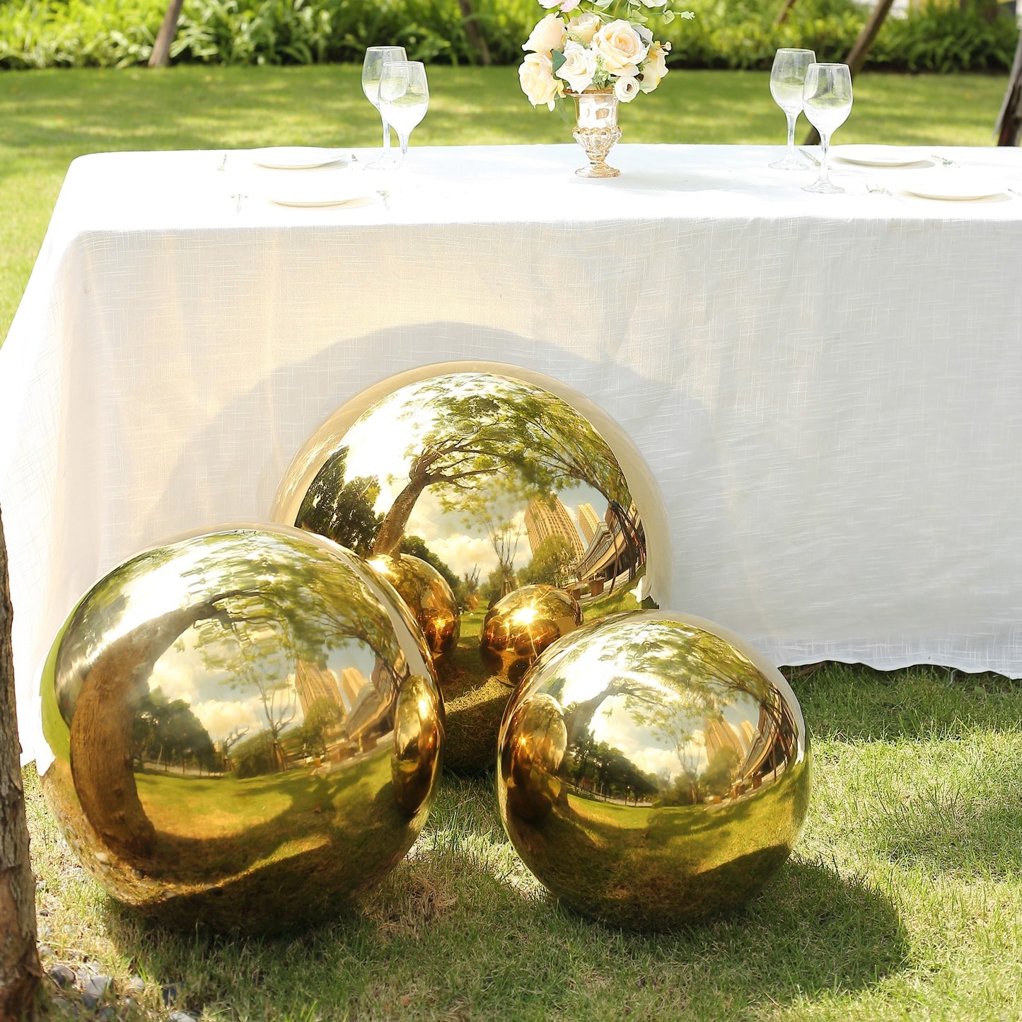 Gold reflective garden globe spheres on grass.