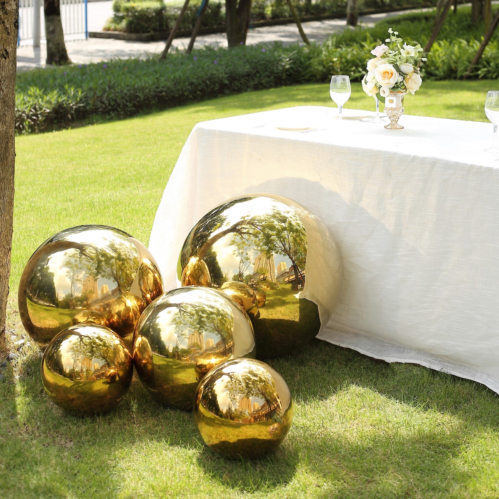 Gold reflective garden globe sphere in a green lawn setting.