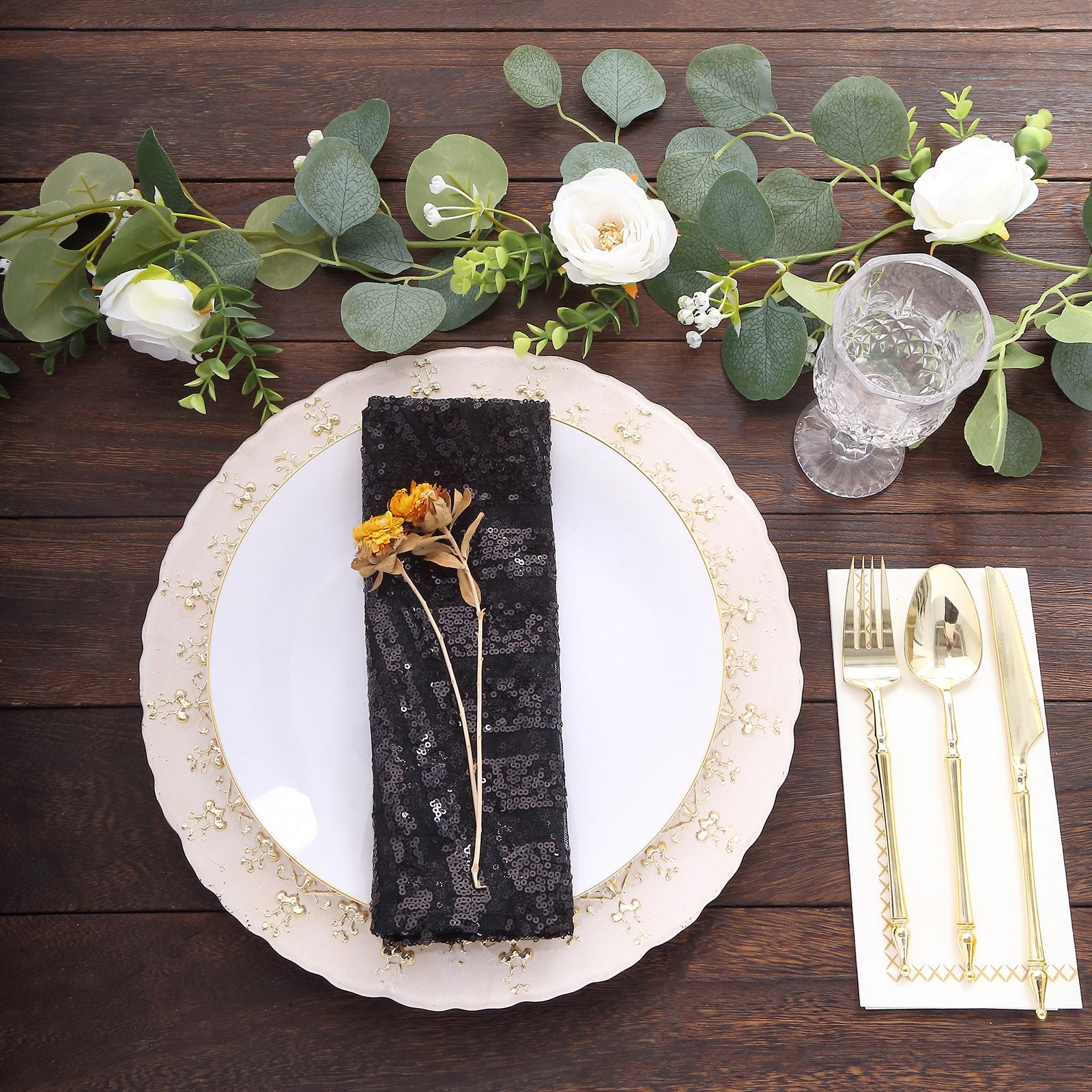 Black geometric diamond glitz sequin cloth napkin on a decorative dinner plate.