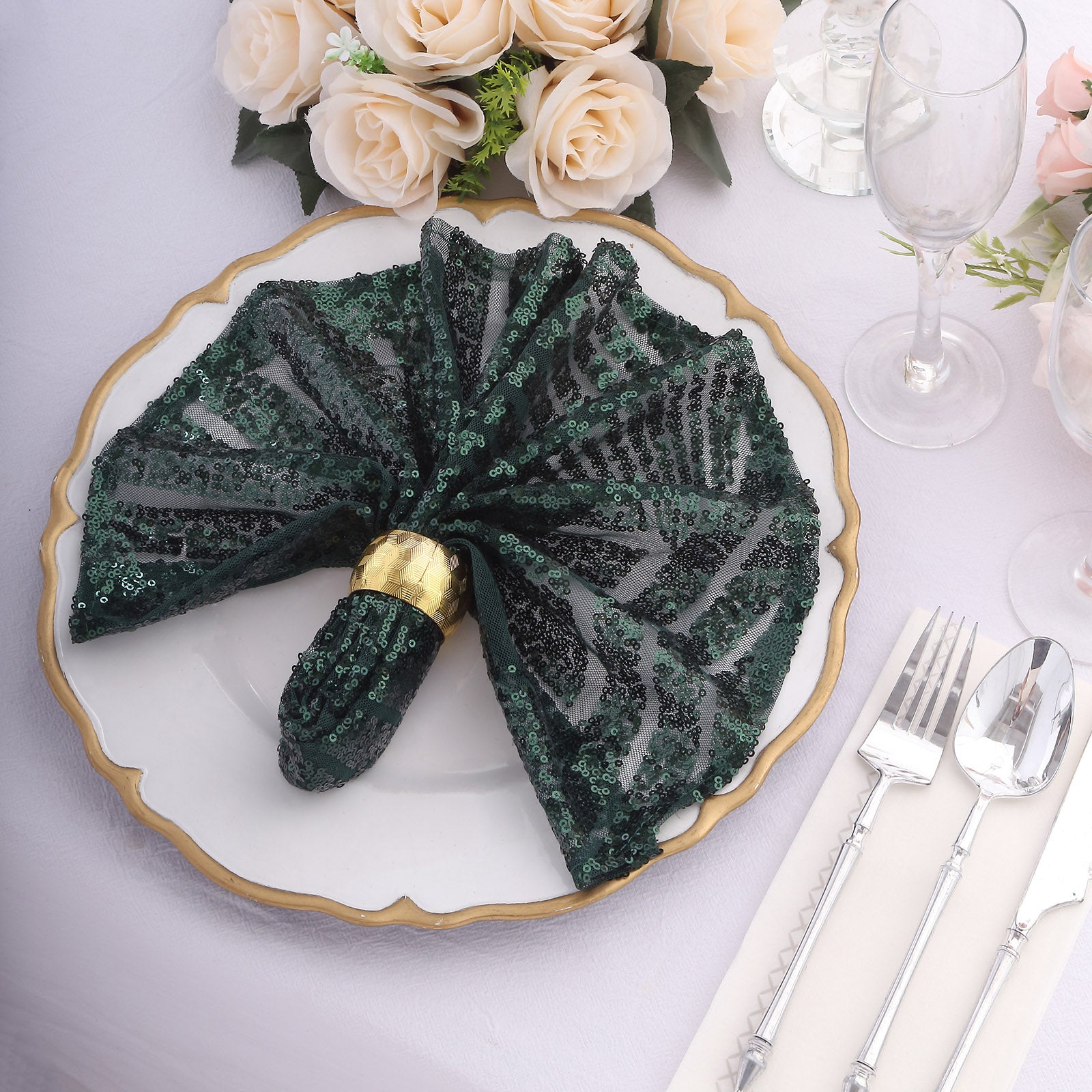 Emerald green sequin cloth napkin elegantly styled on a dinner plate.