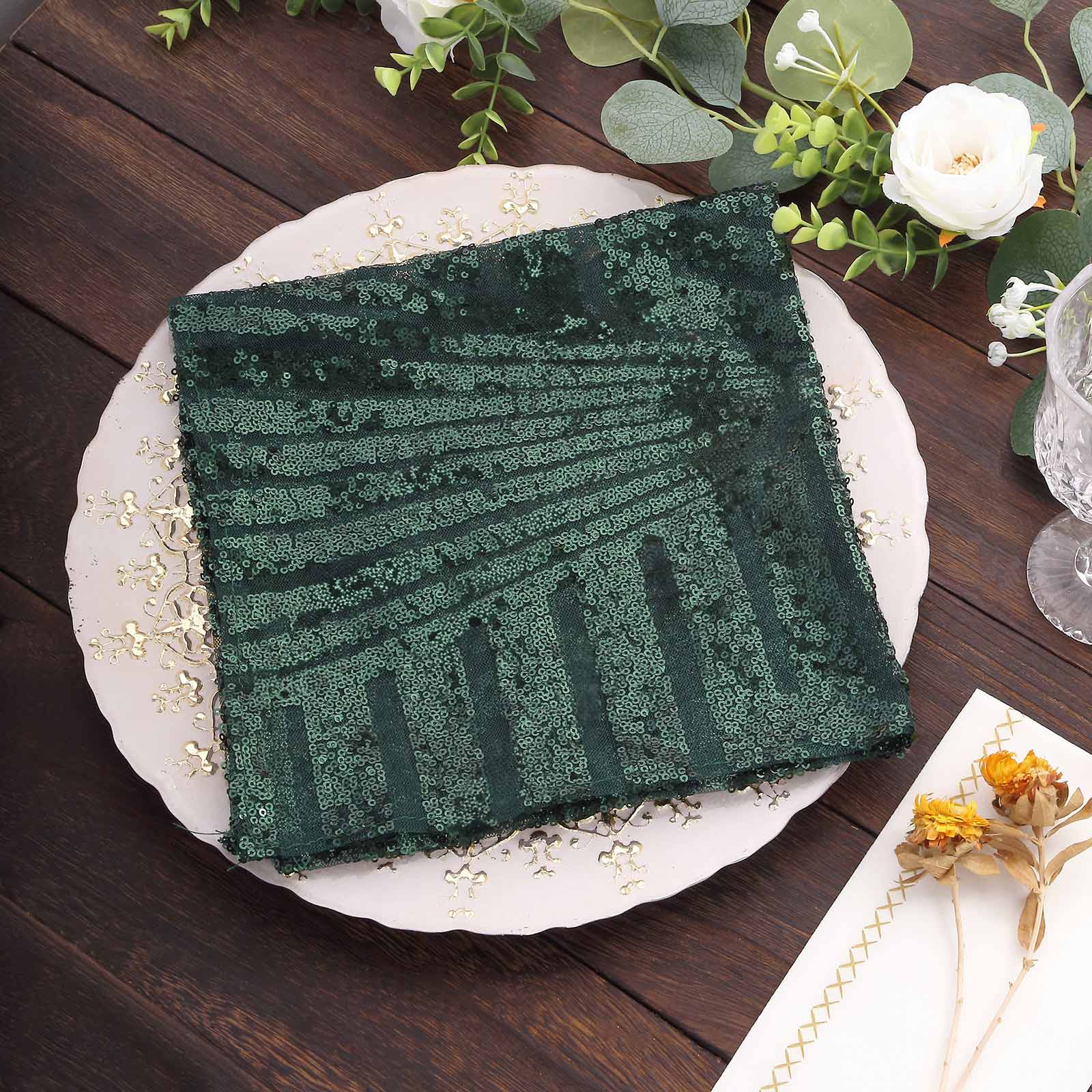 Emerald green geometric diamond glitz sequin cloth napkin on a decorative plate.