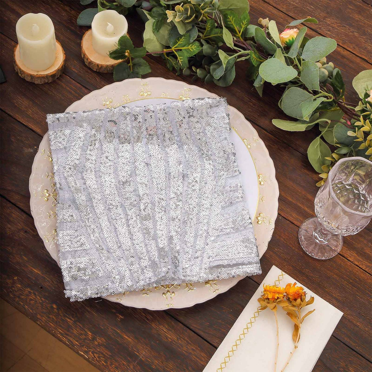 Silver geometric diamond glitz sequin cloth napkin on a decorative dinner plate.