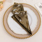 Shiny black and gold foil dinner napkin in a disco mirror ball theme.