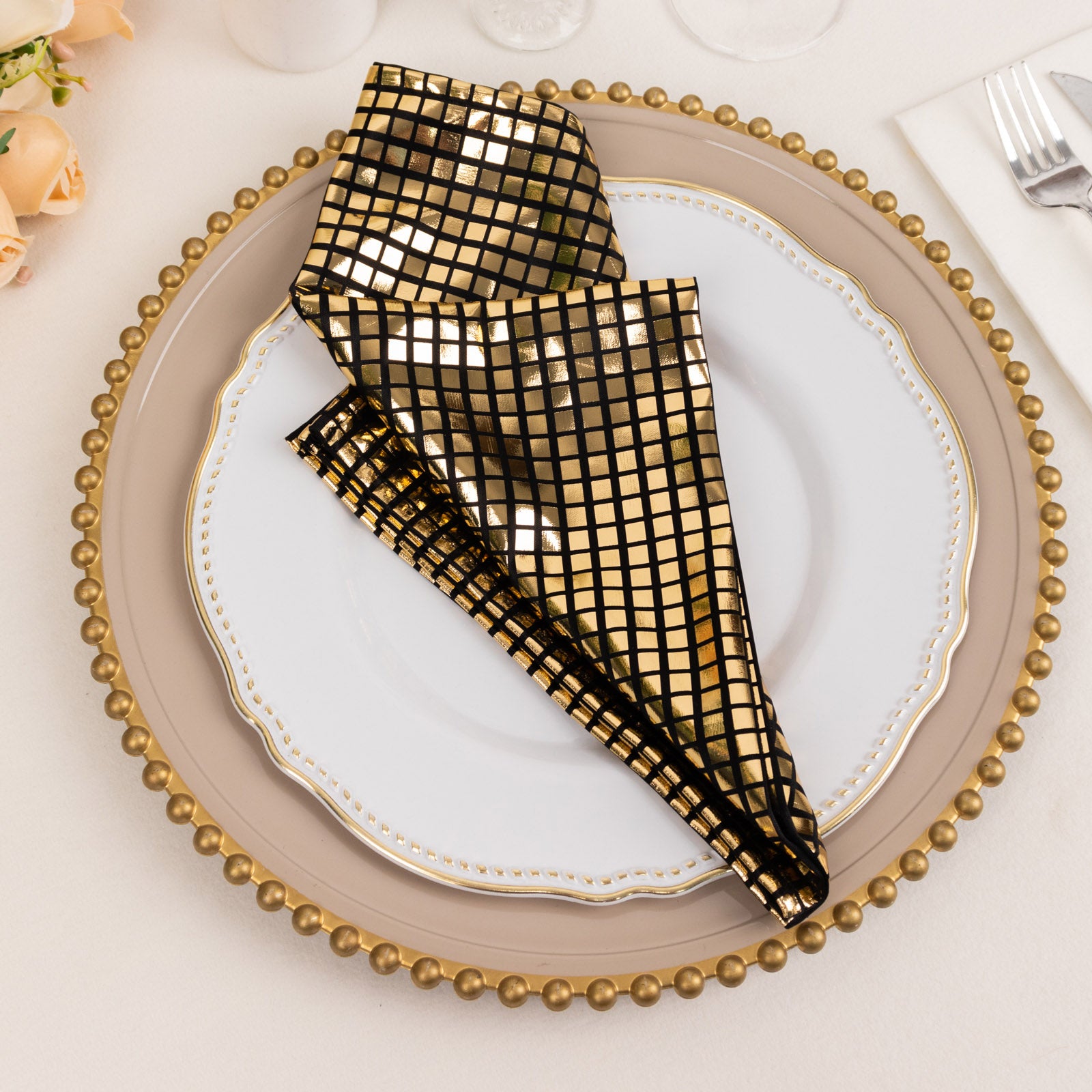 Shiny black and gold foil dinner napkin in a disco mirror ball theme.