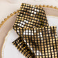 Shiny black and gold foil dinner napkins with a disco mirror ball theme.