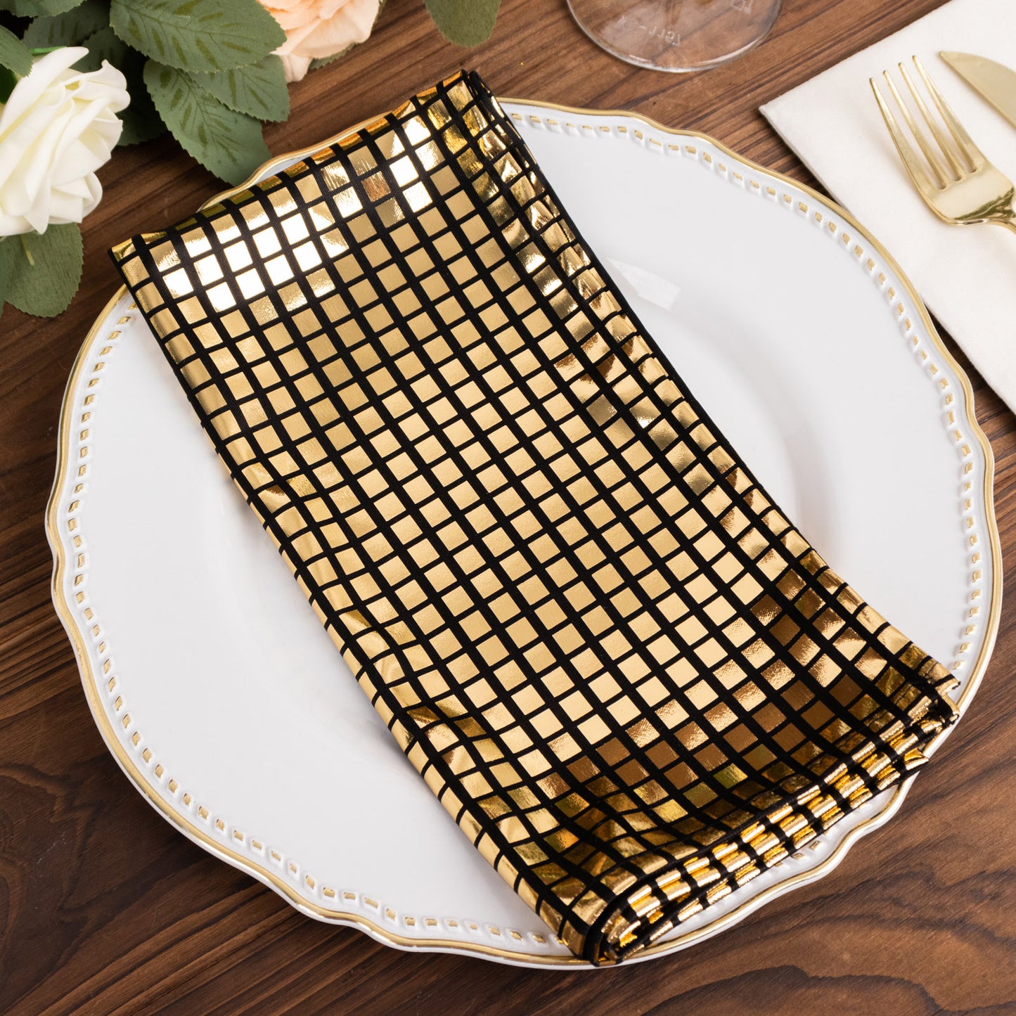 Shiny black and gold foil dinner napkin for a disco-themed table setting.