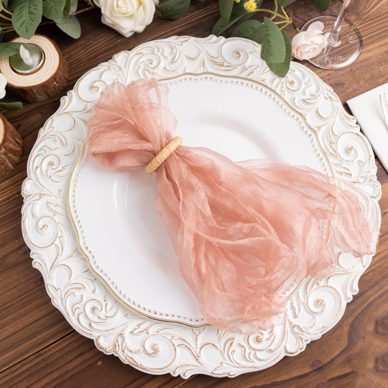 Dusty rose sheer crinkled organza dinner napkins on an ornate white plate.