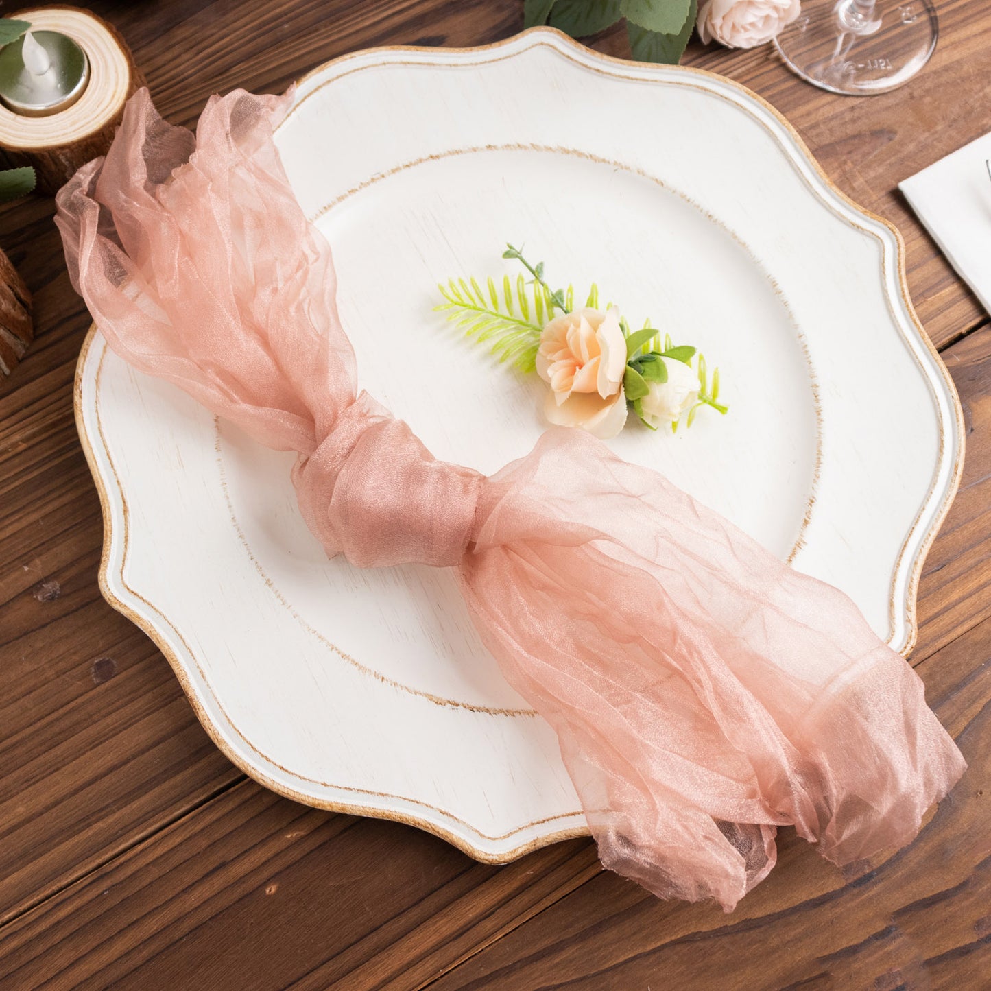 Dusty rose sheer crinkled organza napkin on a decorative plate.