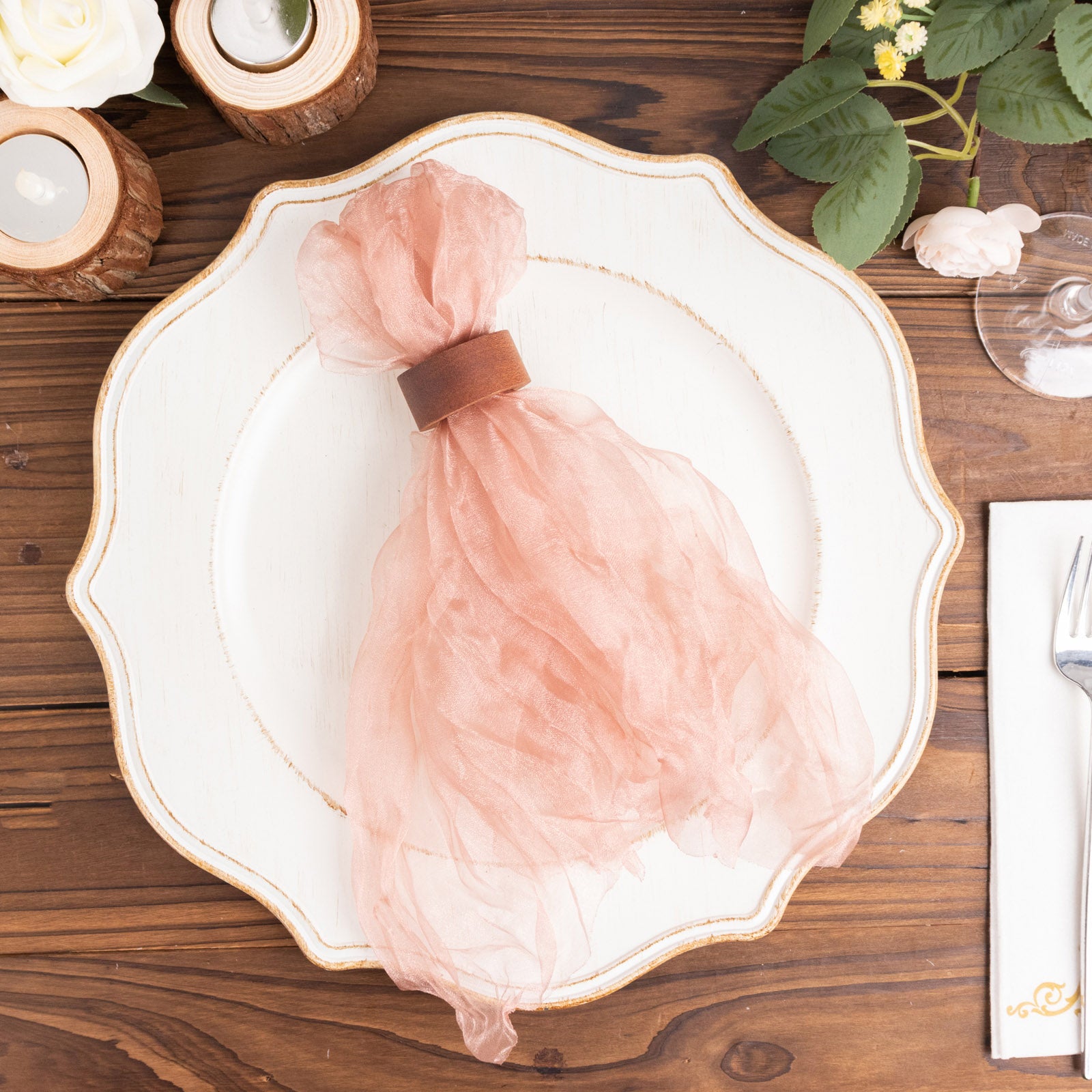 Dusty rose sheer crinkled organza napkins on a decorative plate.