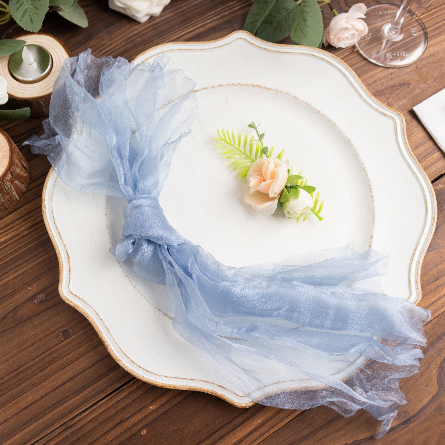 Dusty blue sheer crinkled organza napkins on a decorative plate.