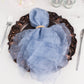 Dusty blue sheer crinkled organza dinner napkin on an elegant plate.