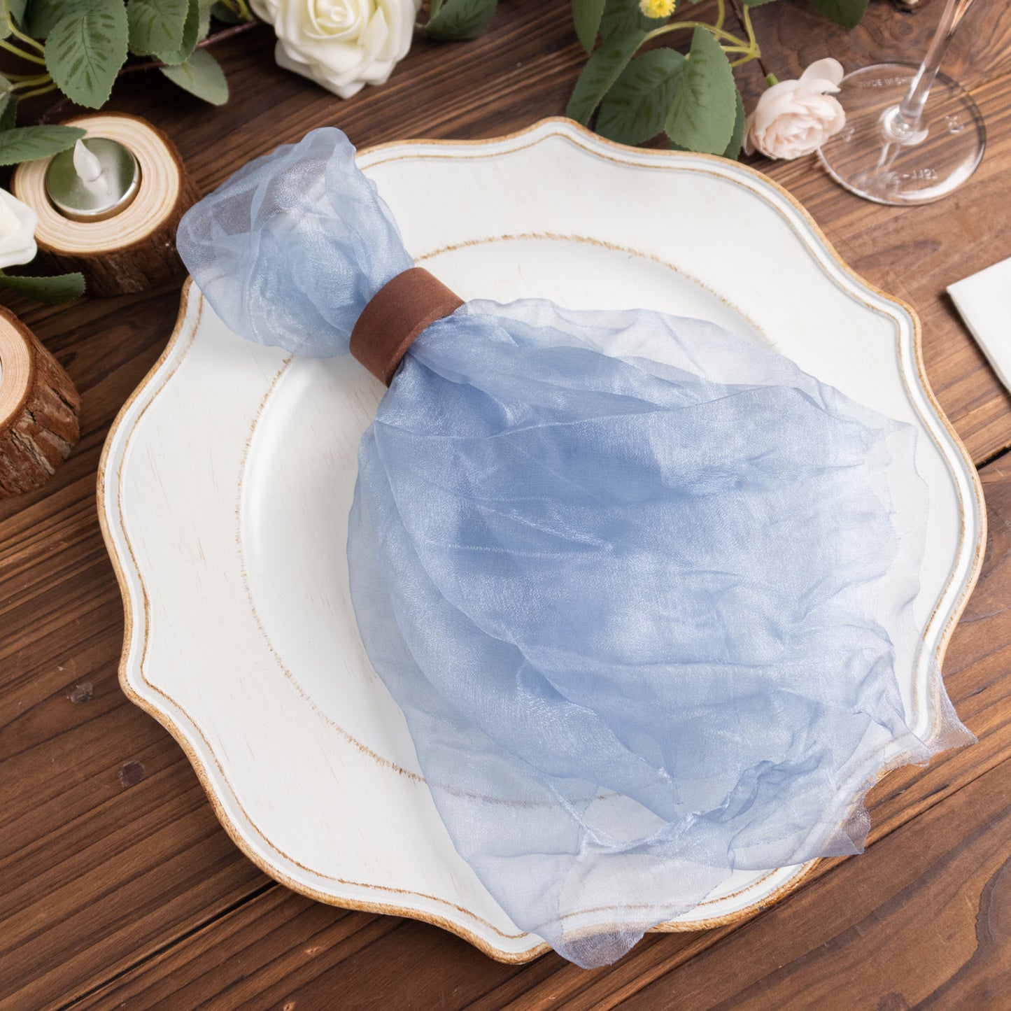 Dusty blue sheer crinkled organza napkin on a decorative plate.