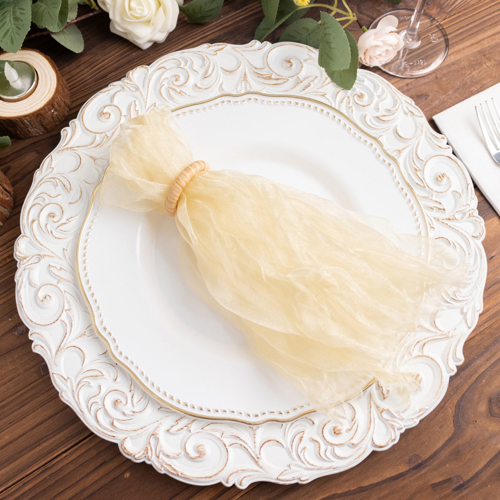 Champagne sheer crinkled organza dinner napkin on an elegant plate.