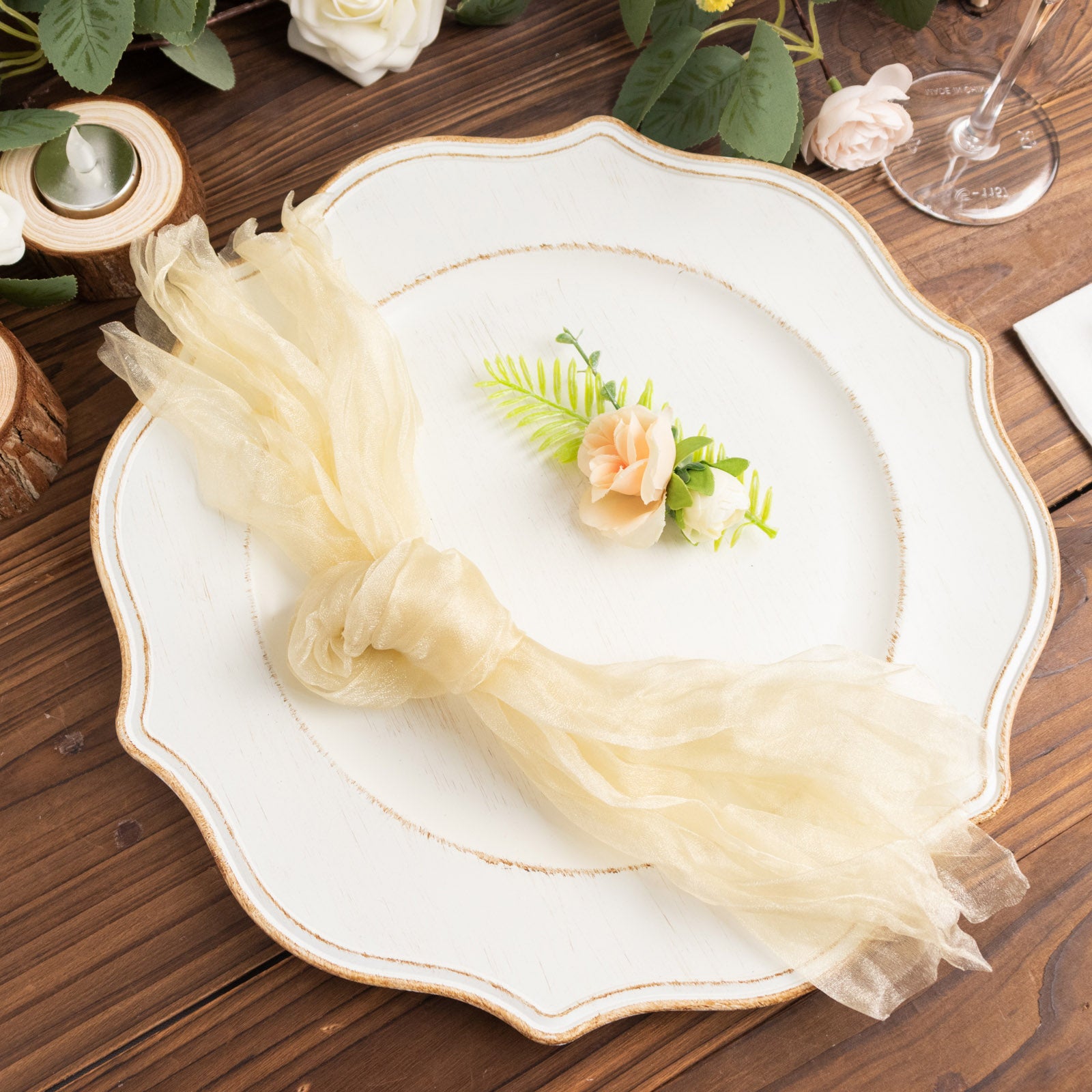 Champagne sheer crinkled organza dinner napkin on a decorative plate.
