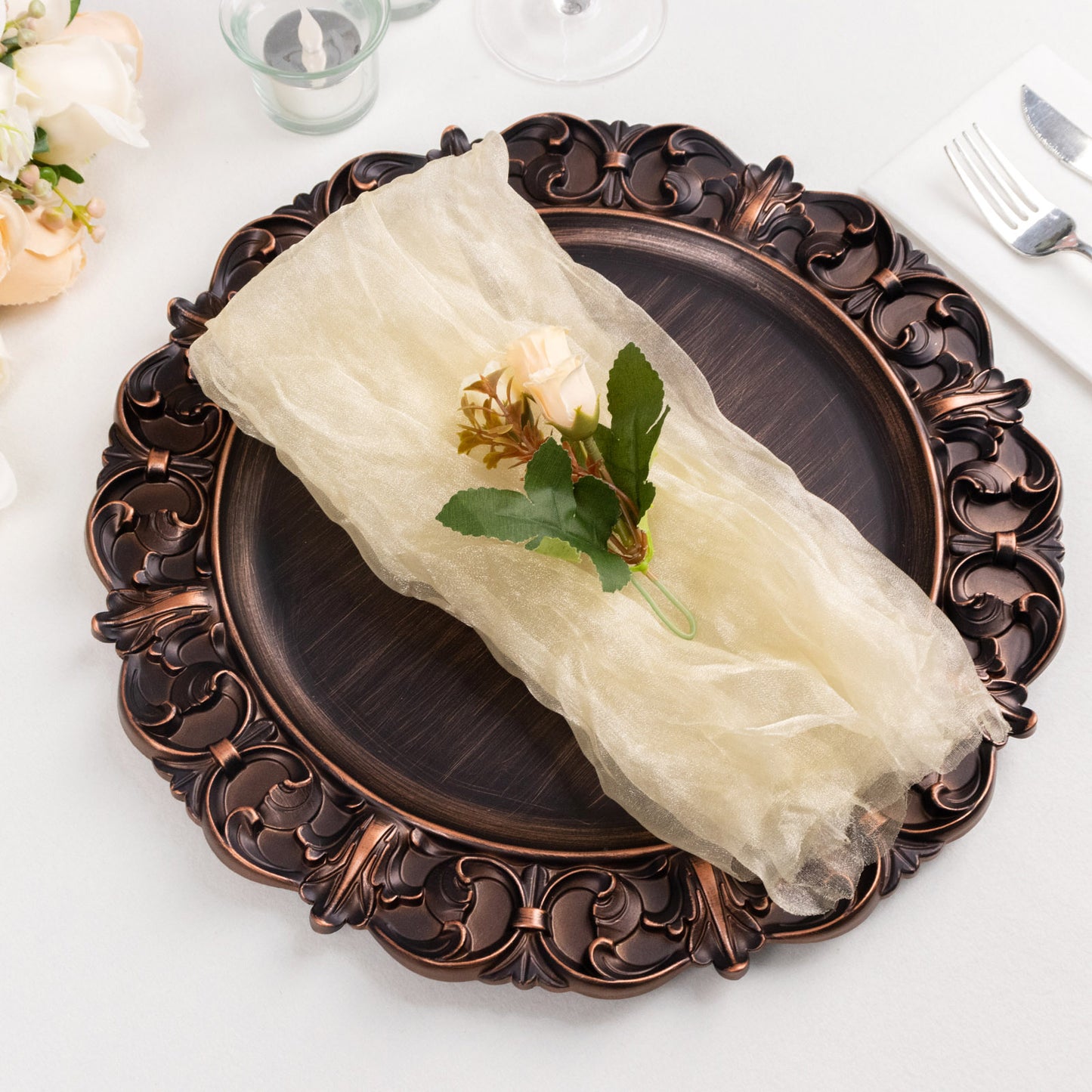 Champagne sheer crinkled organza dinner napkin on an elegant plate.