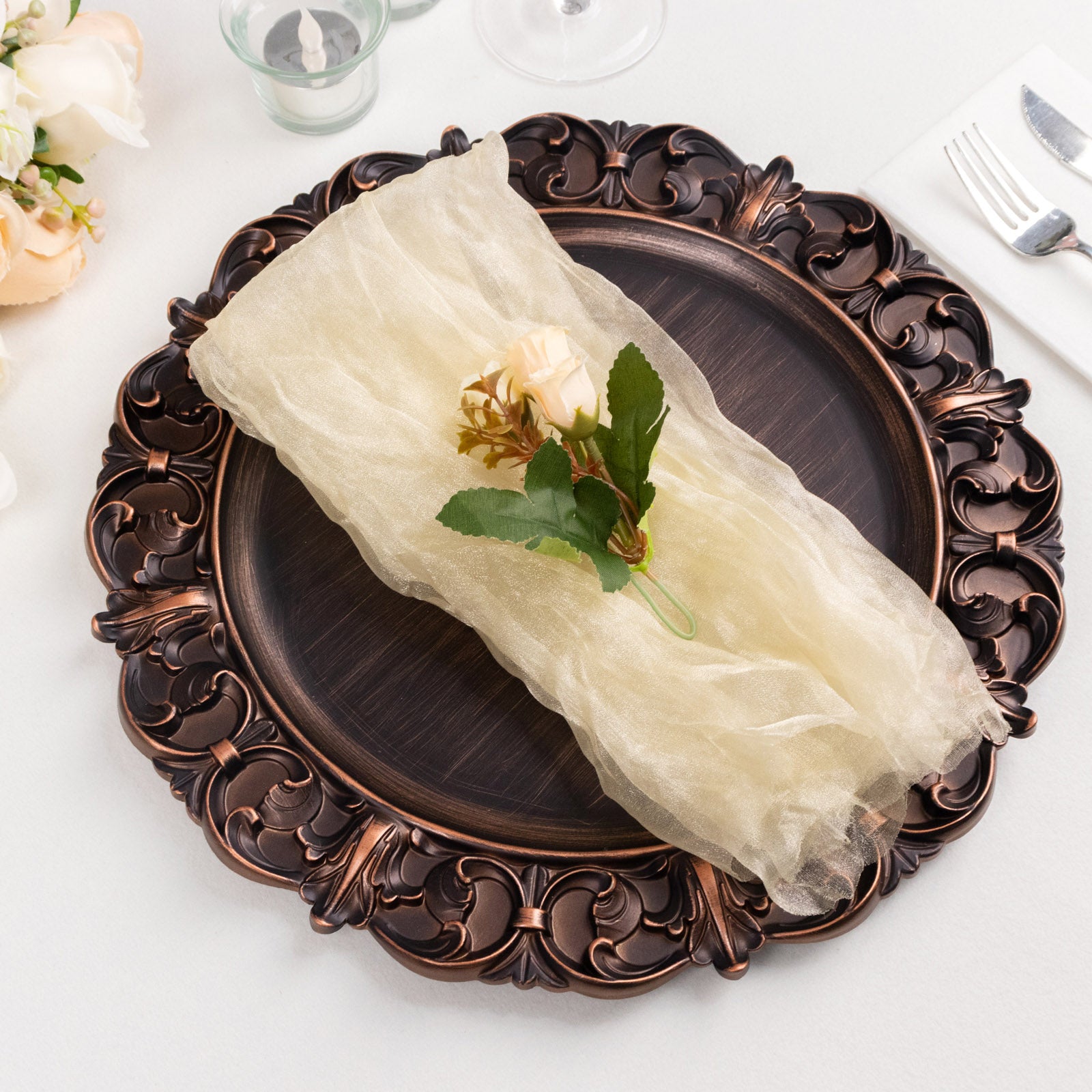 Champagne sheer crinkled organza dinner napkin on an elegant plate.