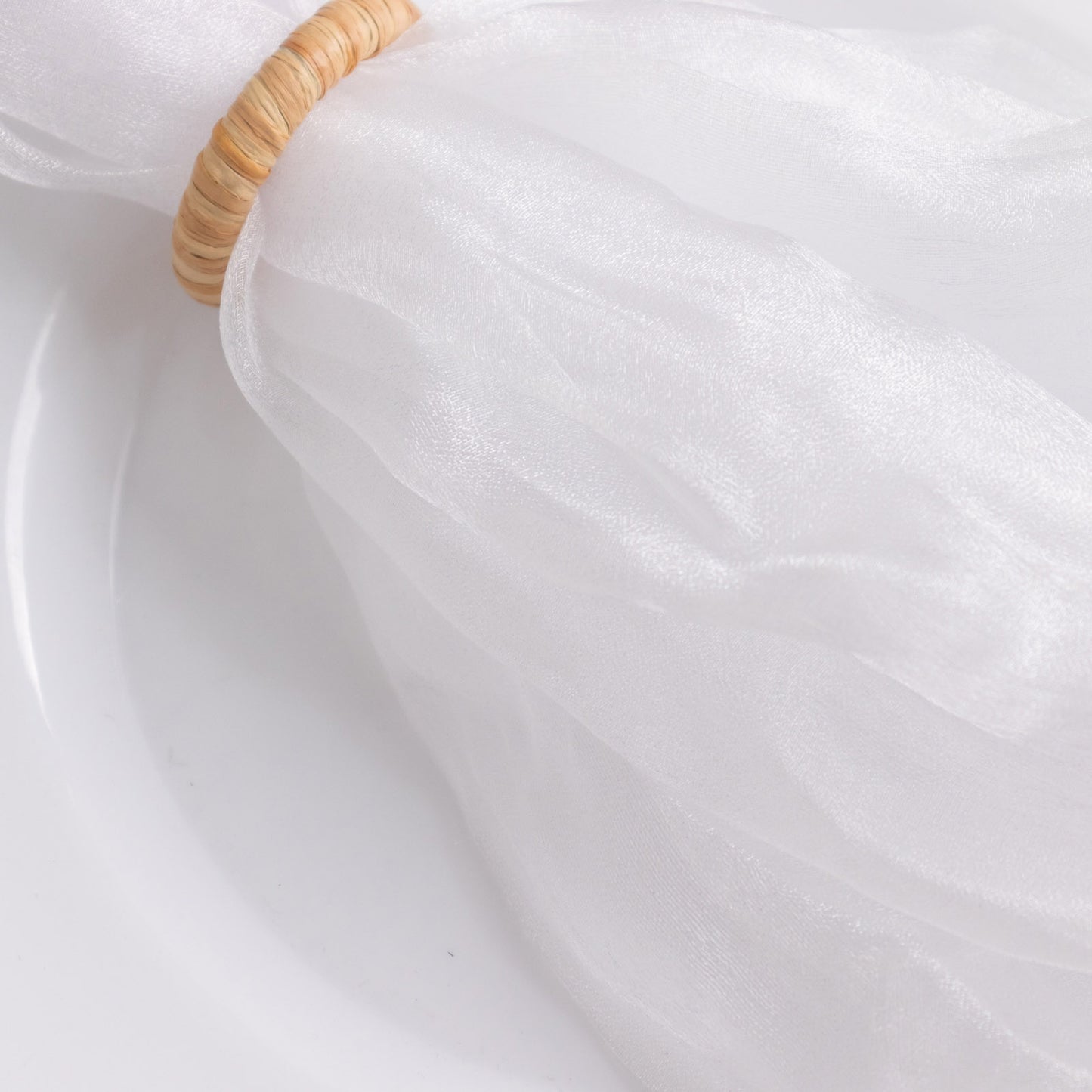 White sheer crinkled organza dinner napkin on a plate.