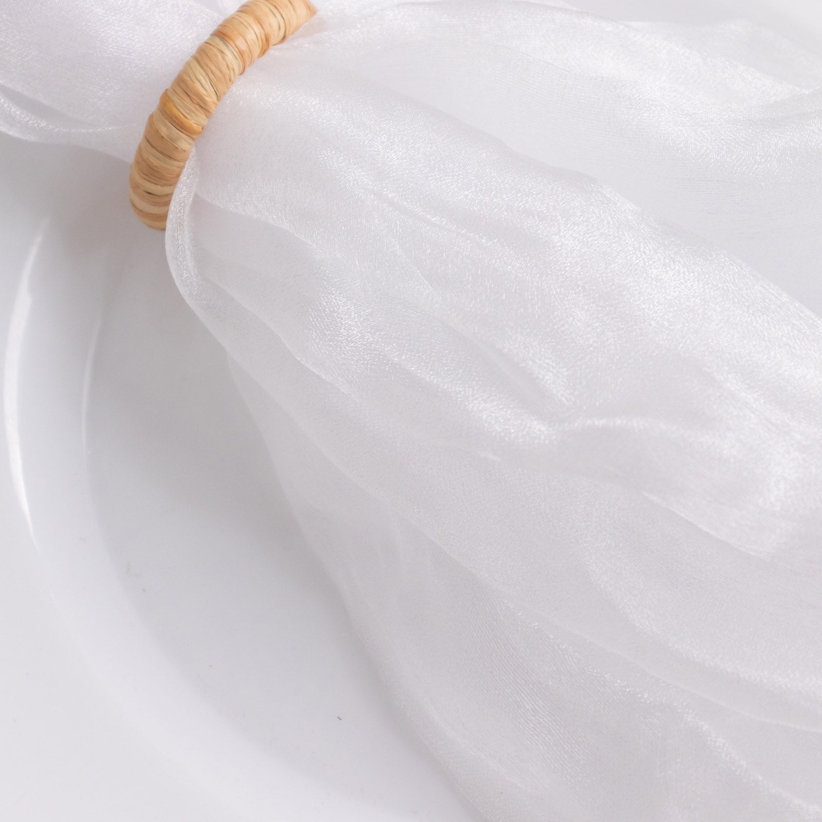 White sheer crinkled organza dinner napkin on a plate.