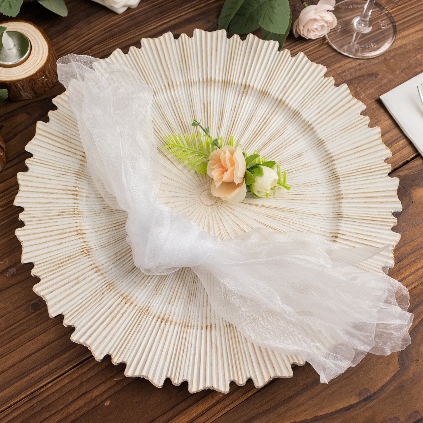 White sheer crinkled organza dinner napkin on a decorative plate.
