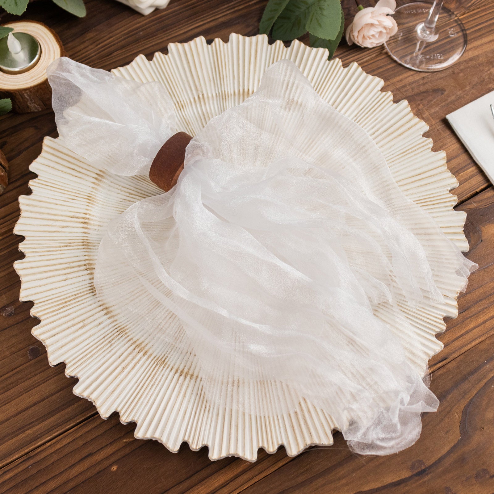 White sheer crinkled organza napkin on a decorative plate.
