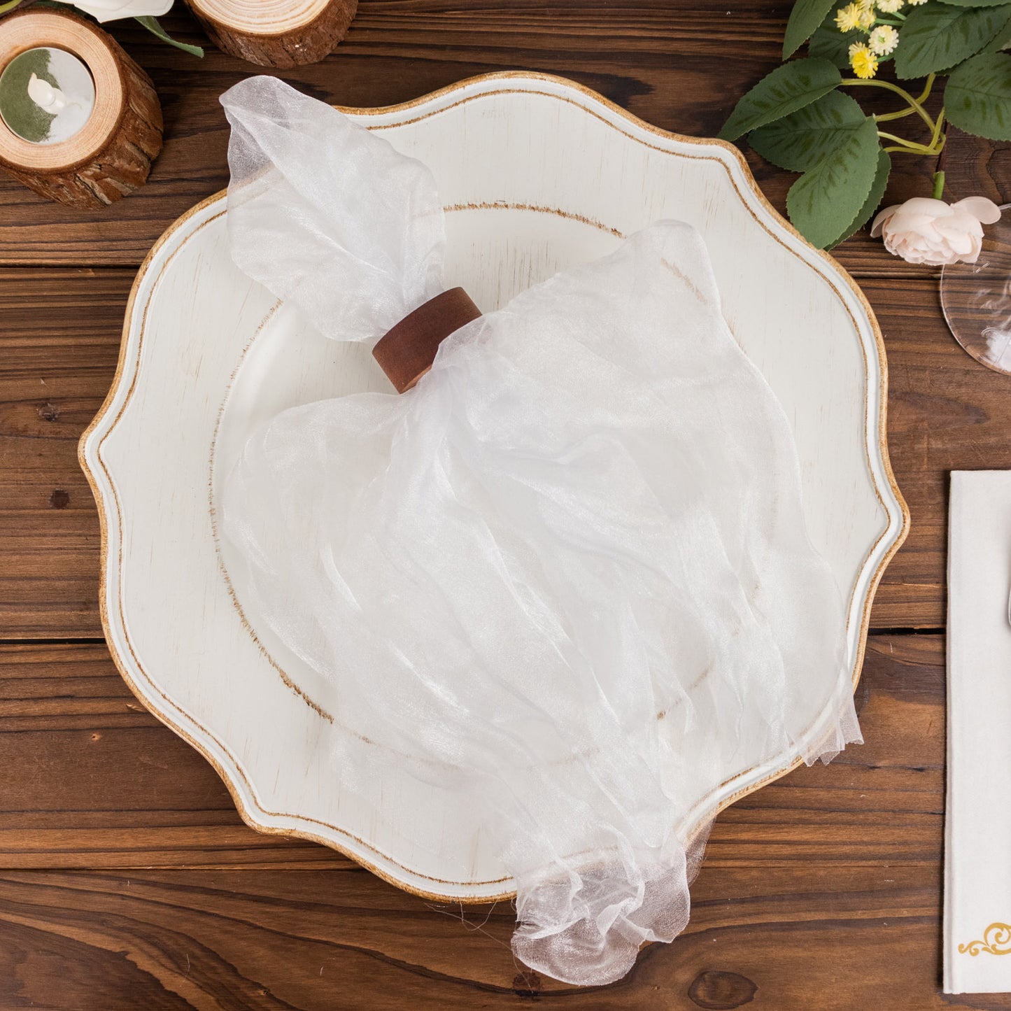 White sheer crinkled organza dinner napkins on a decorative plate.