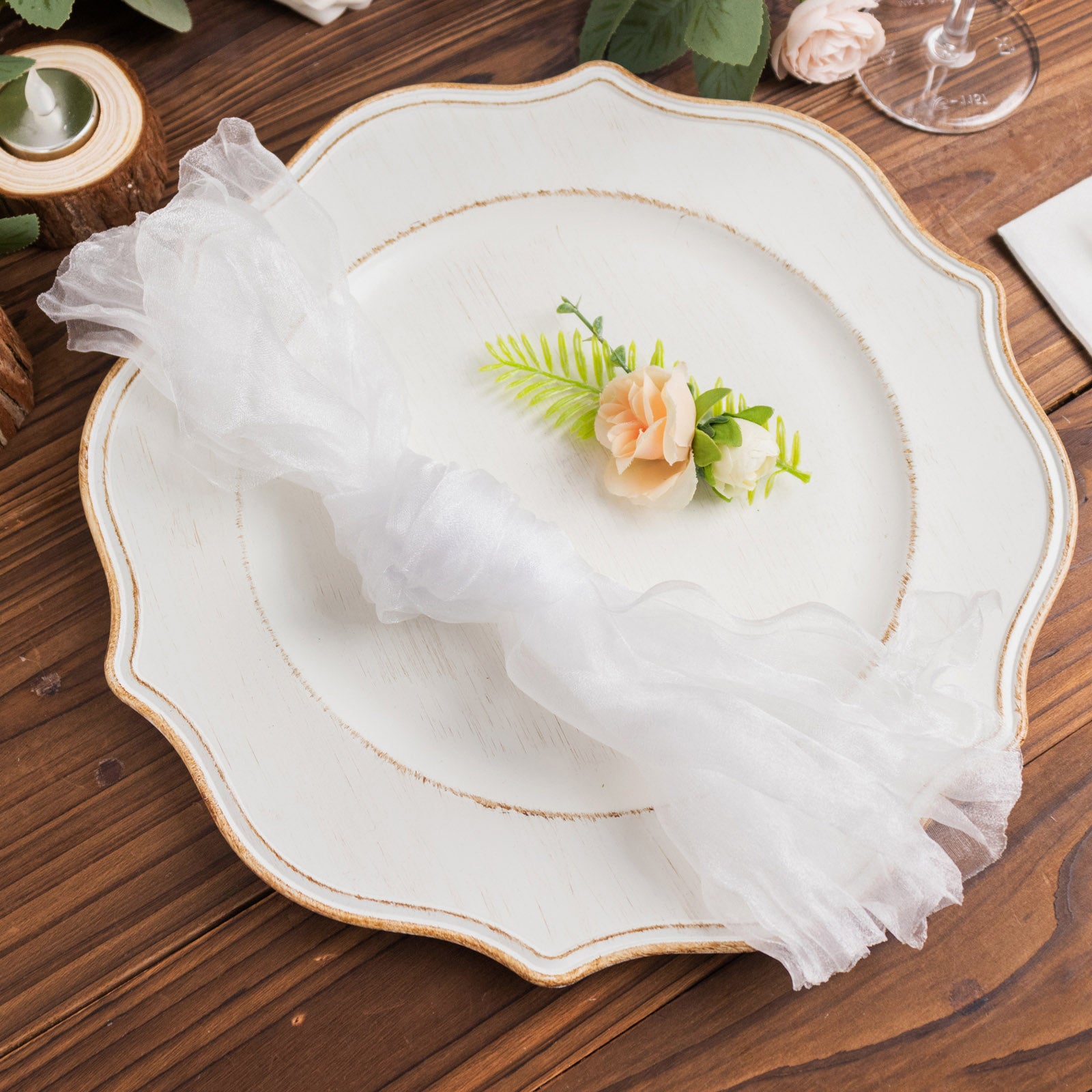 White sheer crinkled organza napkins on a decorative plate.
