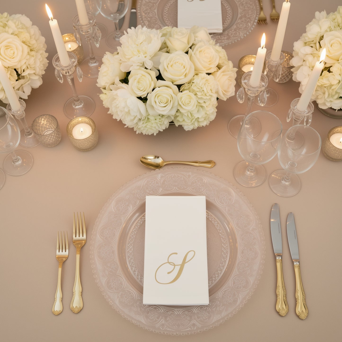 White napkin with gold foil monogram "S" on an elegant dining table setting.