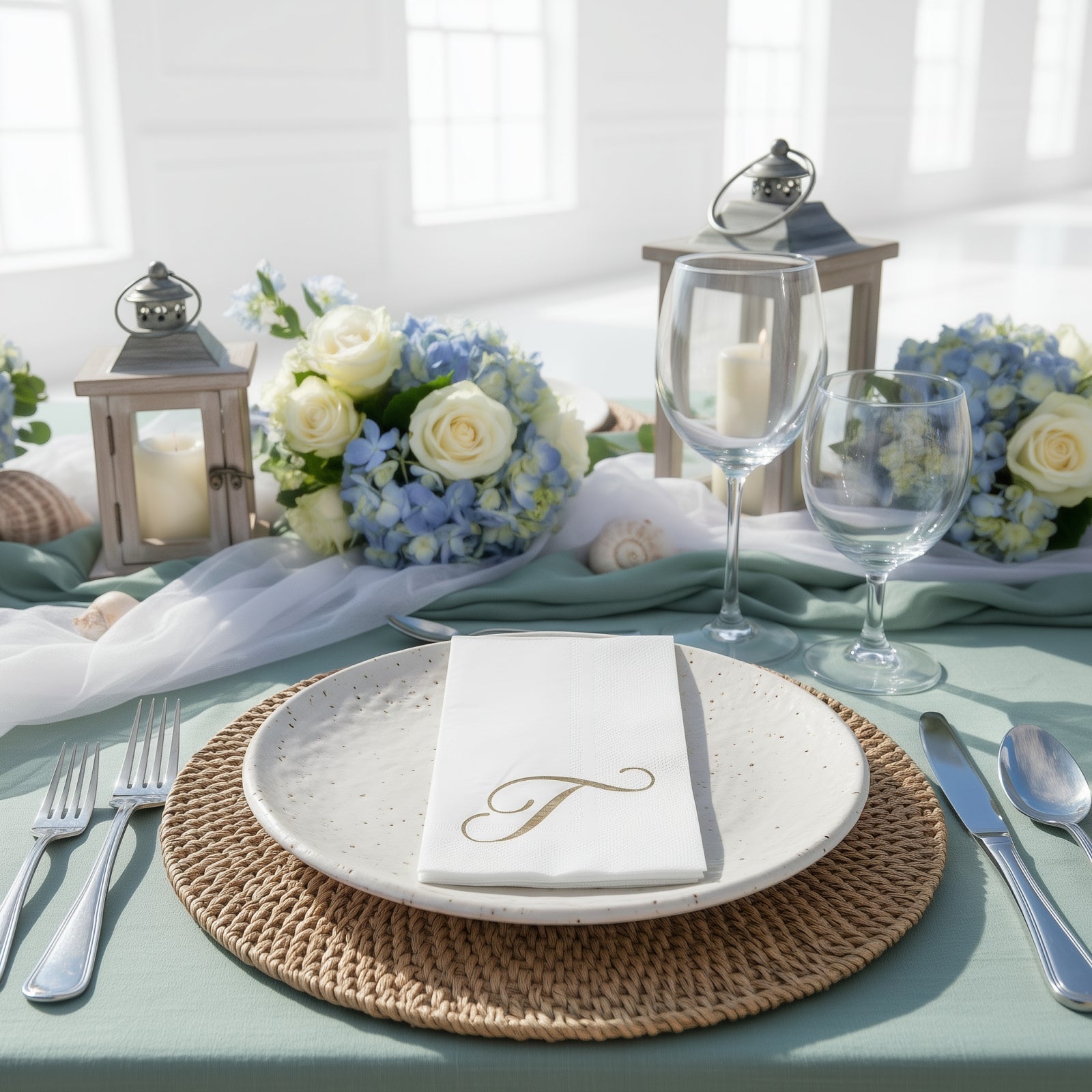 White napkin with gold foil monogram "T" on a beautifully set table.