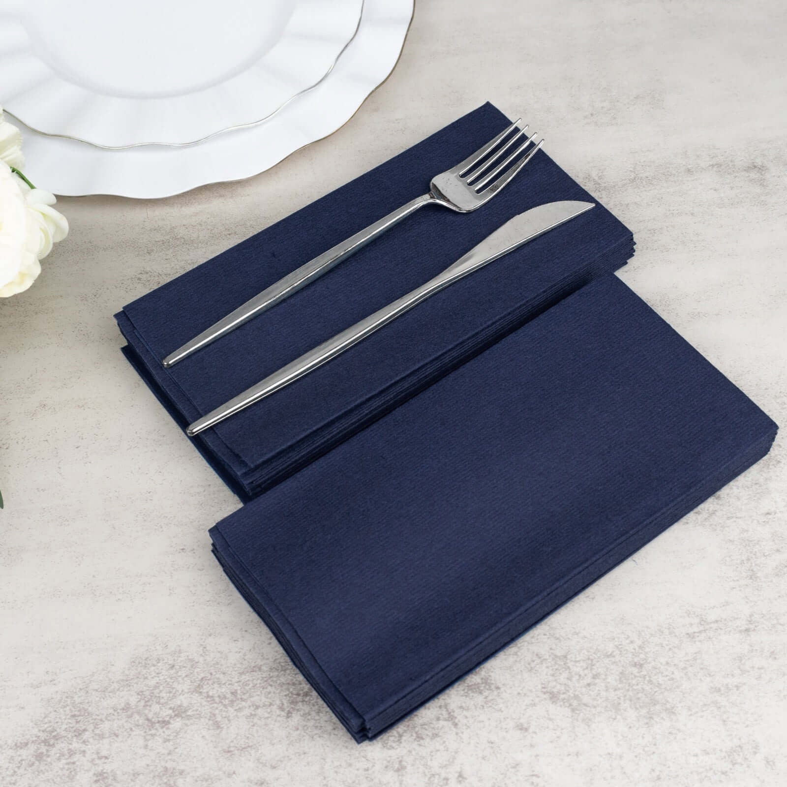 Navy blue linen-feel disposable dinner napkins with silver cutlery.