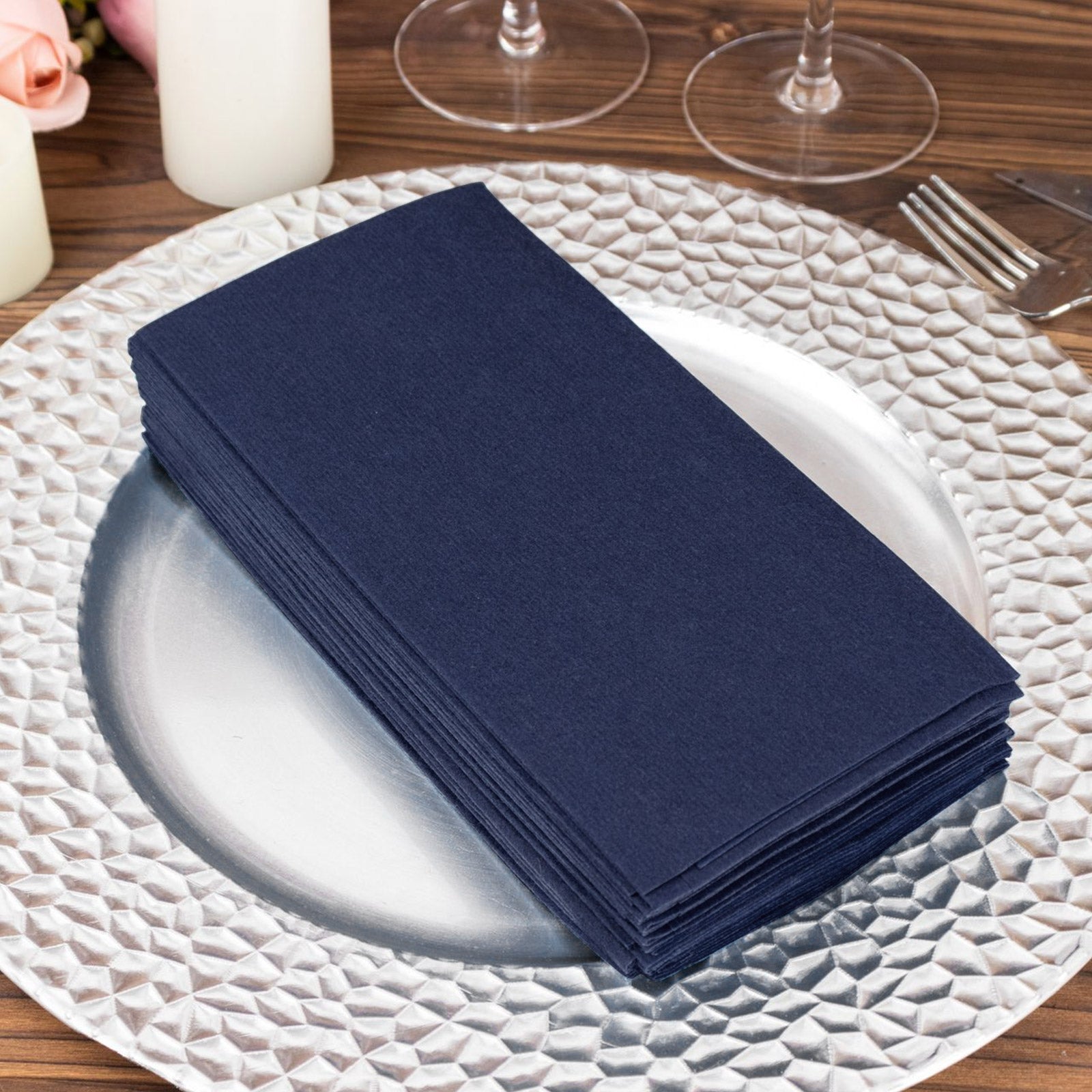 Navy blue linen-feel paper napkins stacked on a decorative plate.