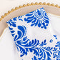 Royal blue and white damask flocking taffeta napkin on a decorative plate.