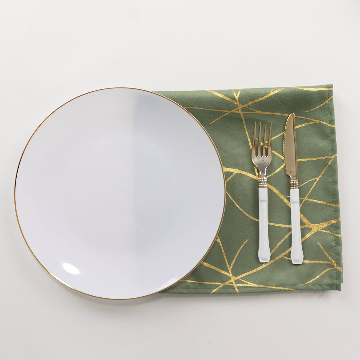 Dusty sage green dinner napkin with gold foil tree branch pattern.