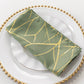 Dusty sage green cloth dinner napkin with gold foil tree branch pattern.