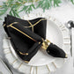 Modern black and geometric gold dinner napkin on a white plate.