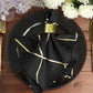 Modern black and geometric gold dinner napkins on a plate.