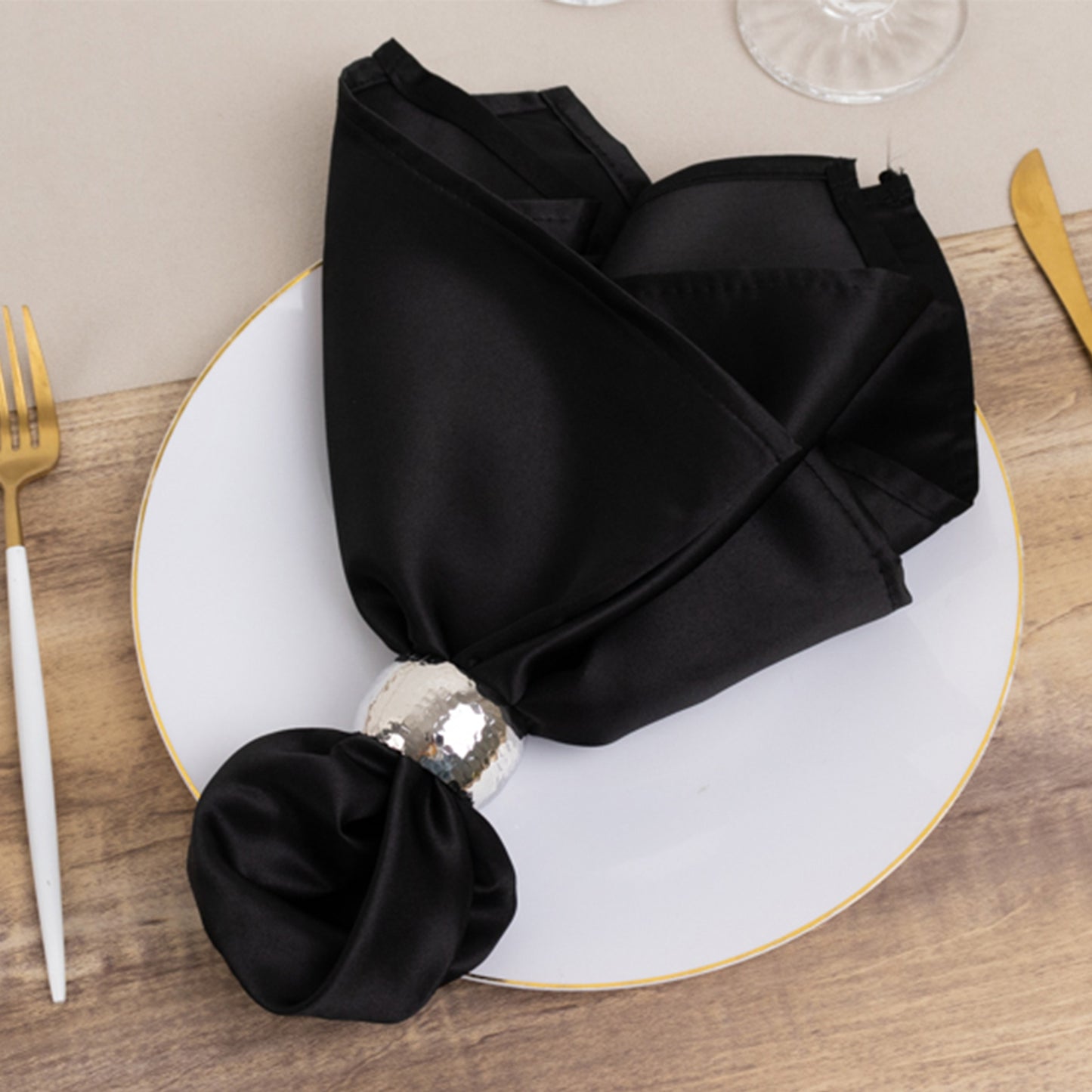 Black satin napkin elegantly arranged on a plate.