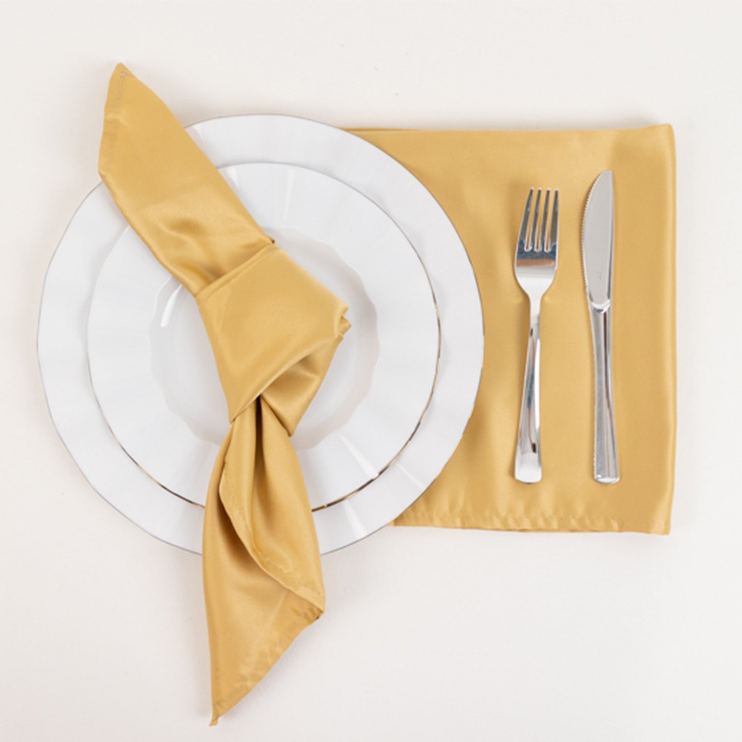 Champagne satin napkins on a table setting with a plate and utensils.