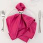 Fuchsia satin napkins elegantly styled on a dinner plate.