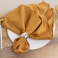 Gold satin napkins elegantly arranged on a plate.